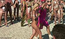 While some of them are just nude, the women dance on the beach in rather provocative way